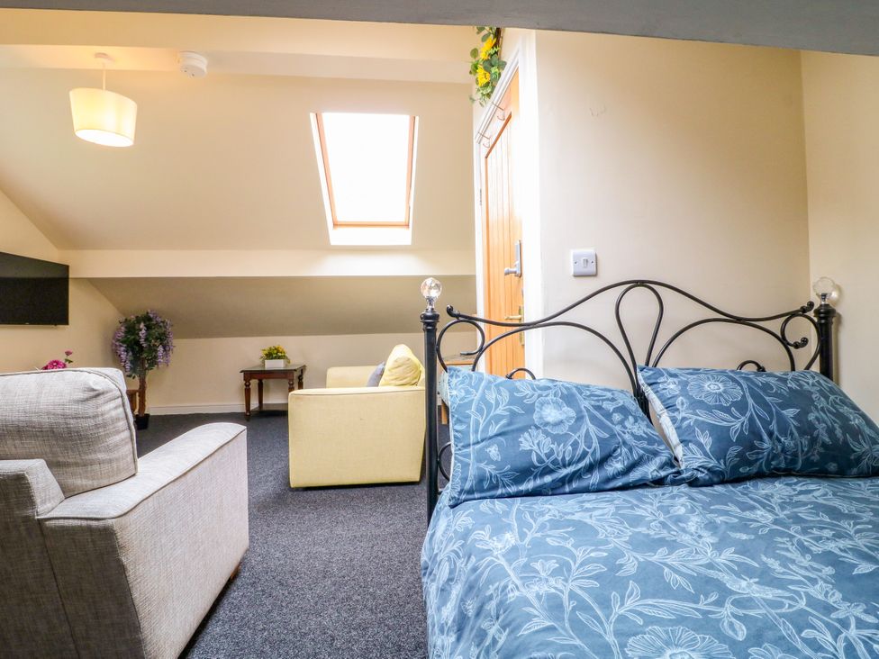 A bedroom with a bed and seating area at Greystones - Apartment B near Buxton