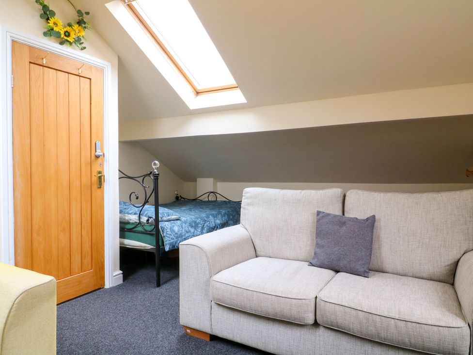 A bedroom with a bed and sofa at Greystones - Apartment B near Buxton