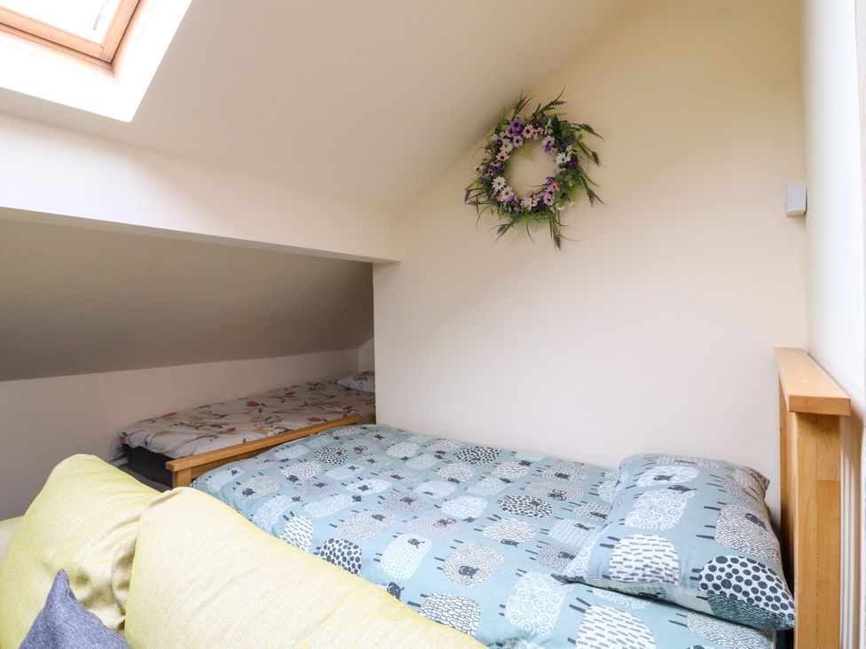 A bedroom with a bed and a decorative wreath at Greystones - Apartment B near Buxton