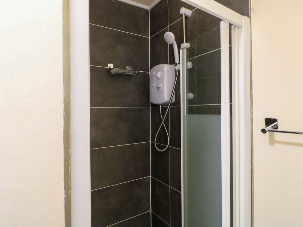 A shower with a showerhead and water heater at Greystones - Apartment B near Buxton