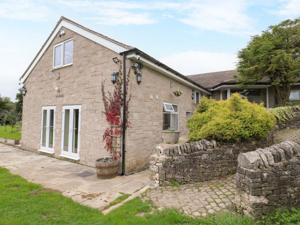 A stone building with windows and door in an outdoor area at Greystones - Apartment B near Buxton