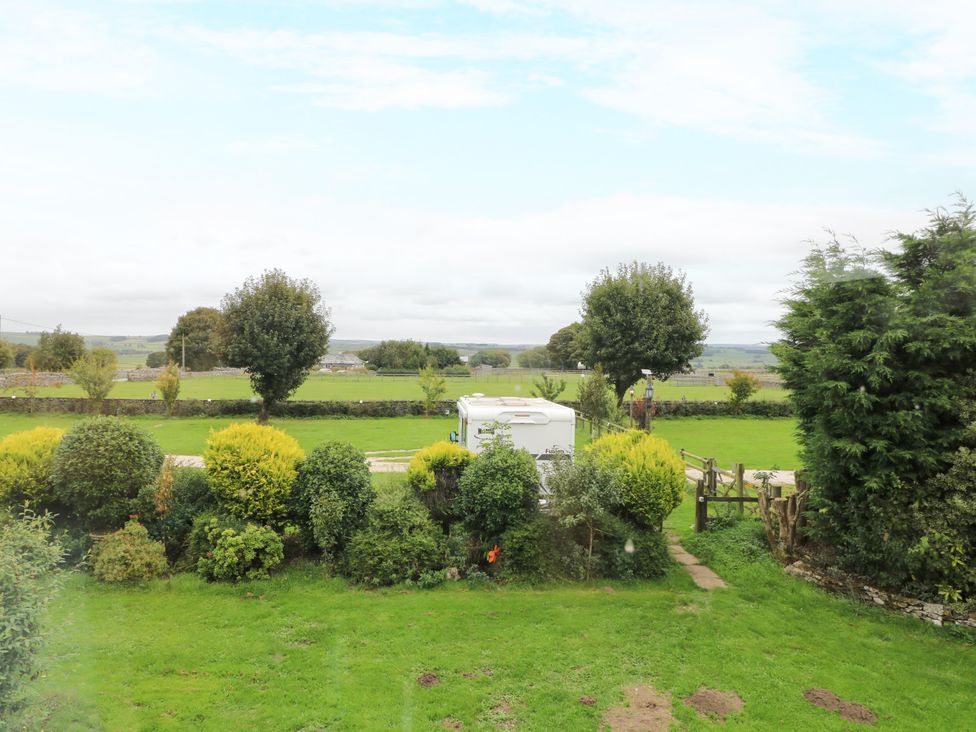 A view of a garden area with a caravan and trees at Greystones - Apartment B near Buxton