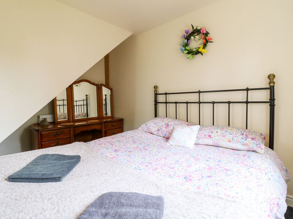 A bedroom with a bed and dresser at Greystones - Apartment C near Buxton
