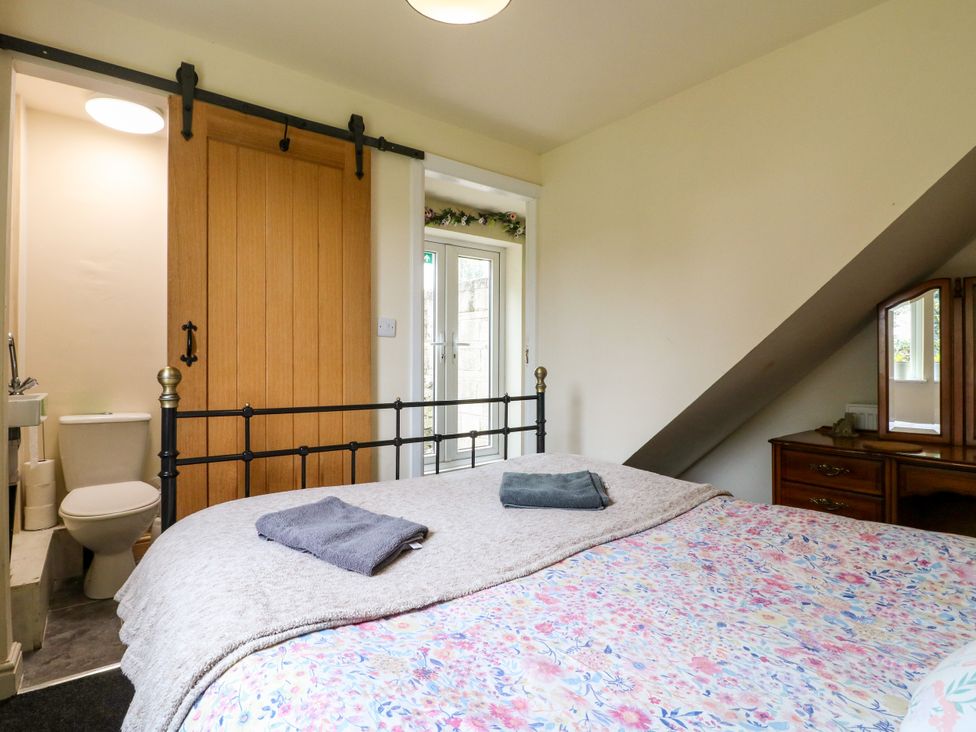 A bedroom with a bed and adjacent bathroom at Greystones - Apartment C near Buxton