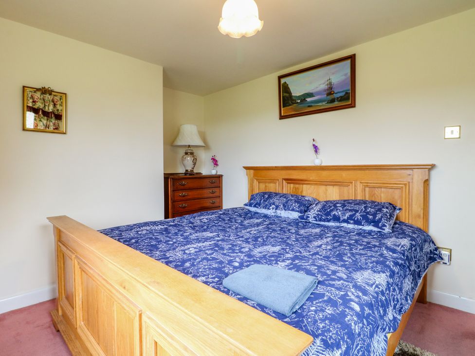 A bedroom with a wooden bed and a lamp at Greystones - apartment D near Buxton