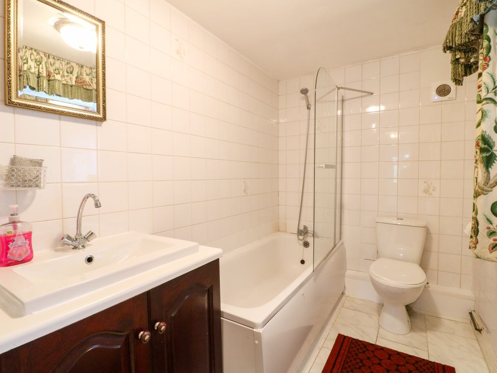 A bathroom with a bathtub, toilet, and sink at Greystones - apartment D near Buxton