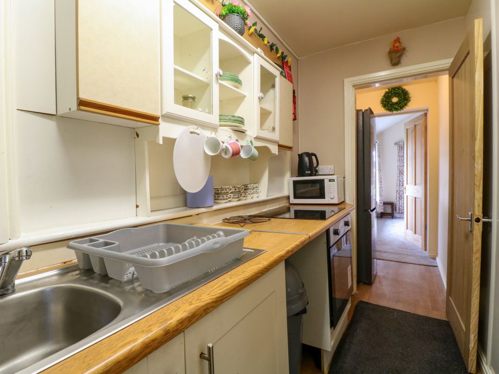 A kitchen with a sink drainer and appliances at Greystones - Apartment E near Buxton