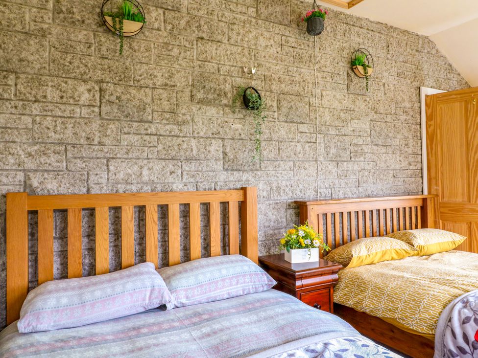 A bedroom with two beds and a nightstand at Greystones - Apartment E near Buxton