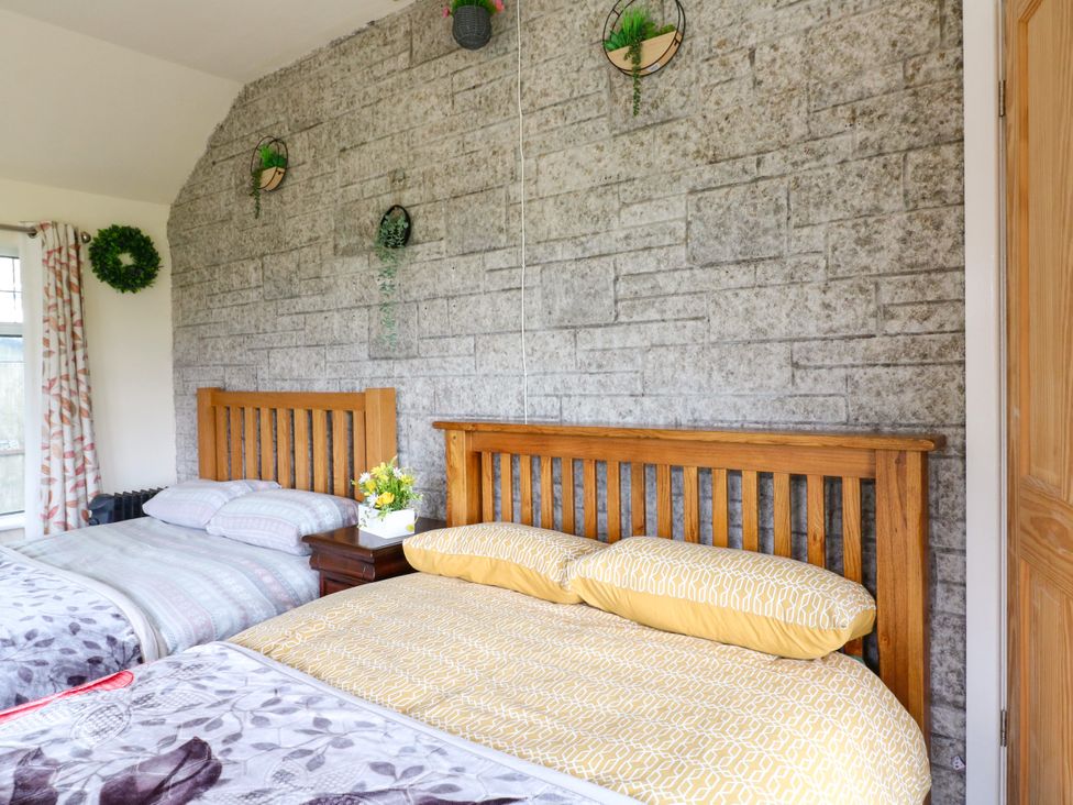 A bedroom with two beds and a nightstand at Greystones - Apartment E near Buxton
