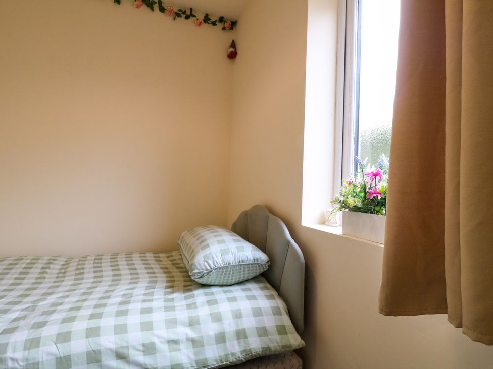 A bedroom with a bed and flower pot on the window at Greystones - Apartment E near Buxton