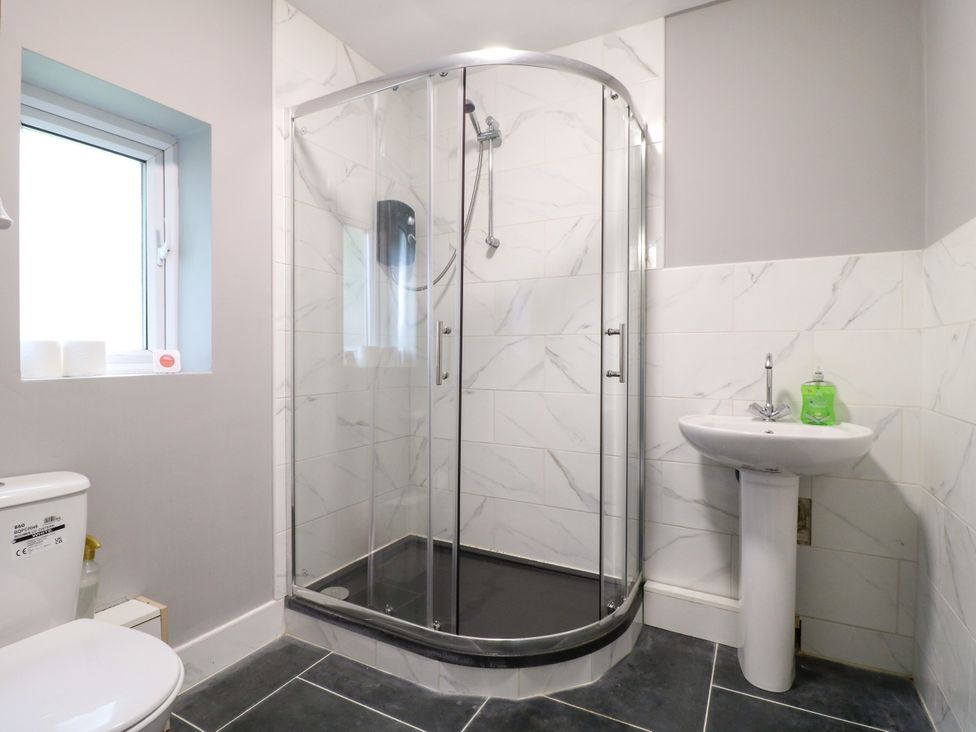 A bathroom with a shower, toilet, and sink at Greystones - Apartment E near Buxton