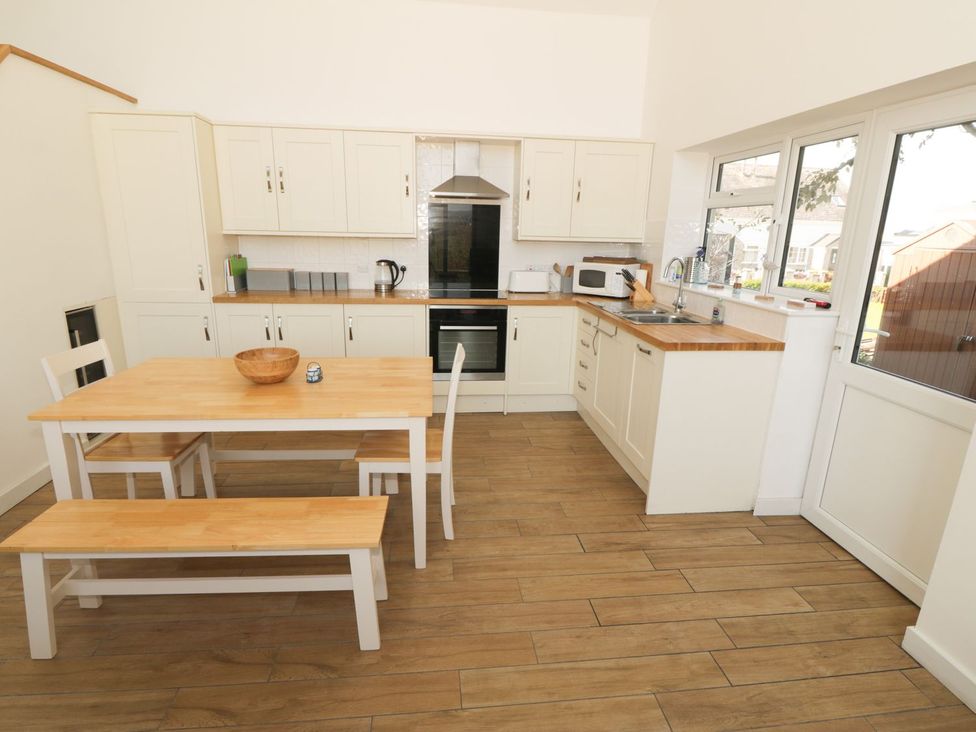 A kitchen with a table and chairs at Cae Mawr in Caernarfon