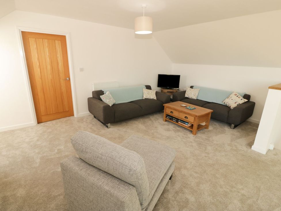 A living room with a sofa and television at Cae Mawr in Caernarfon