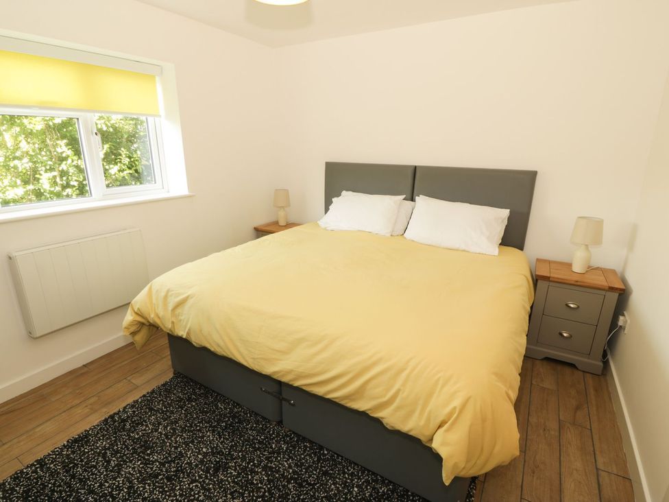 A bedroom with a bed and bedside tables at Cae Mawr in Caernarfon