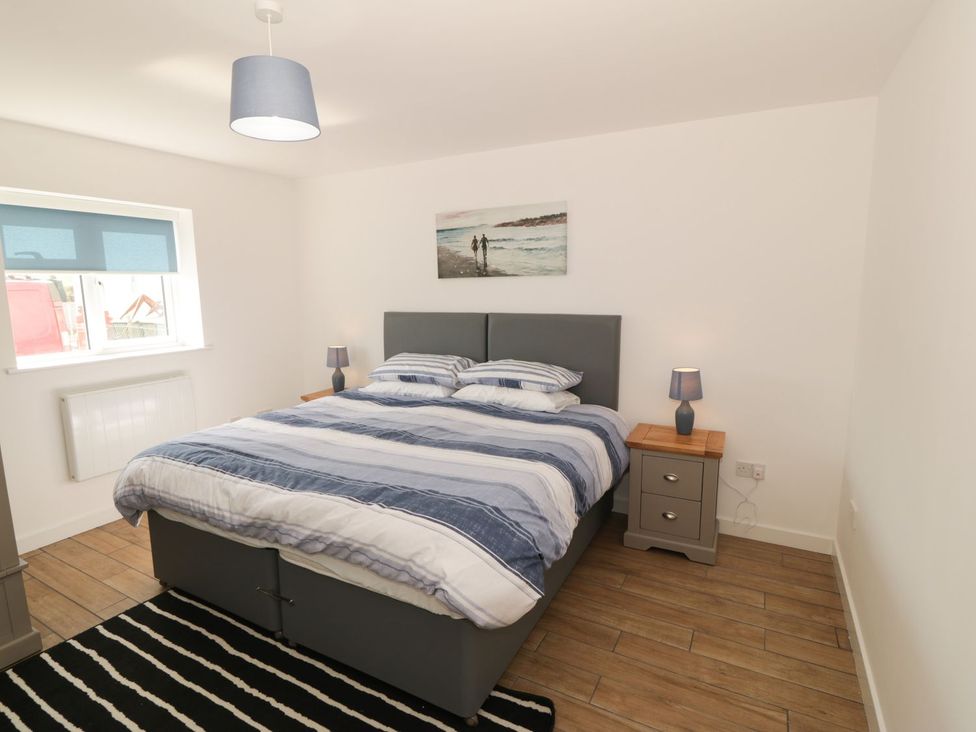A bedroom with a bed and nightstand at Cae Mawr Caernarfon