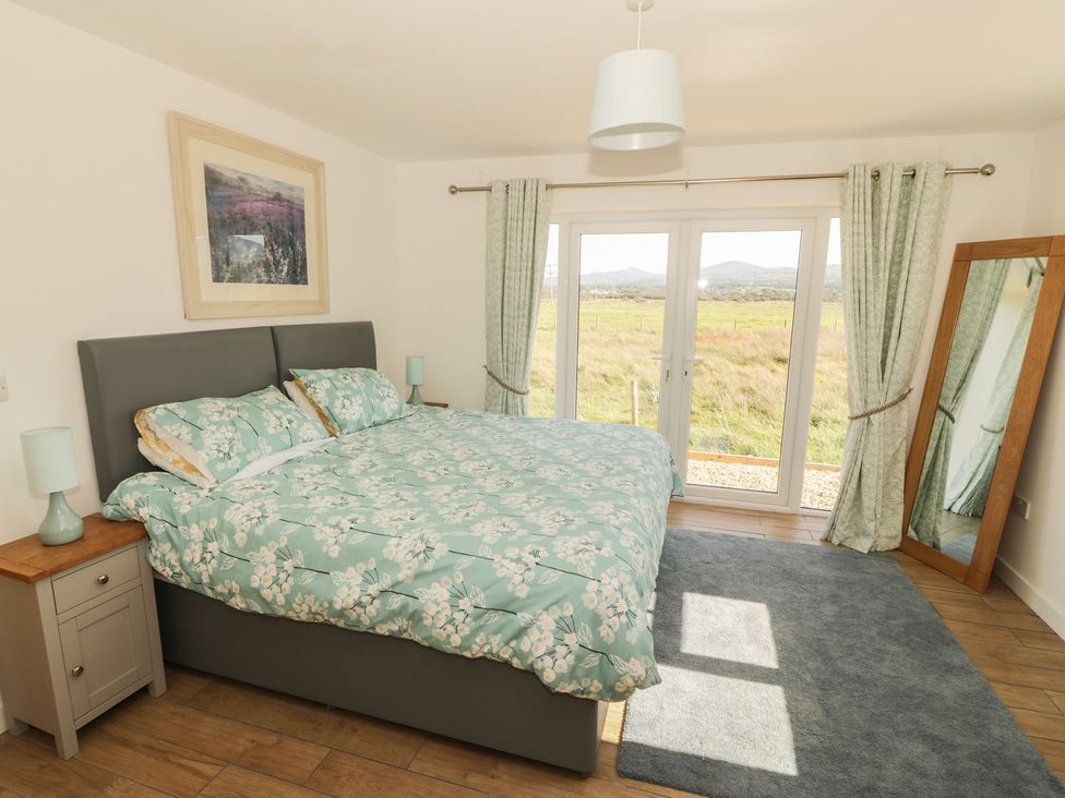 A bedroom with a bed and a view at Cae Mawr in Caernarfon