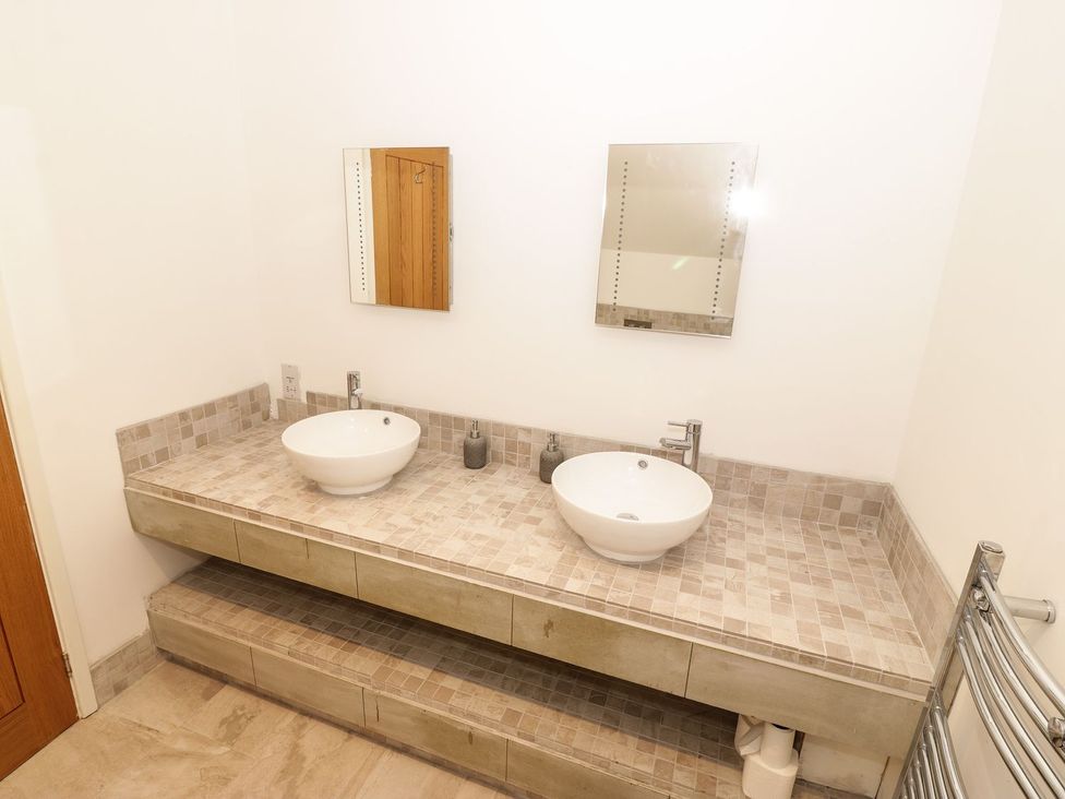 A bathroom with two sinks and mirrors at Cae Mawr in Caernarfon