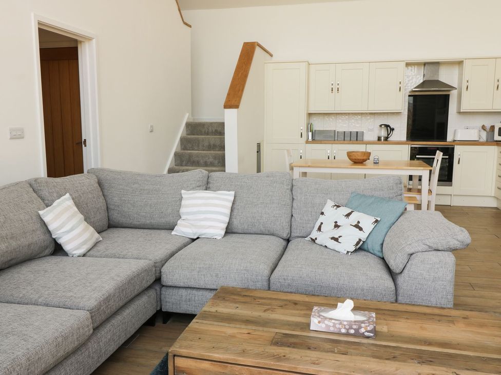 A living room with a grey sofa and a coffee table at Cae Mawr in Caernarfon