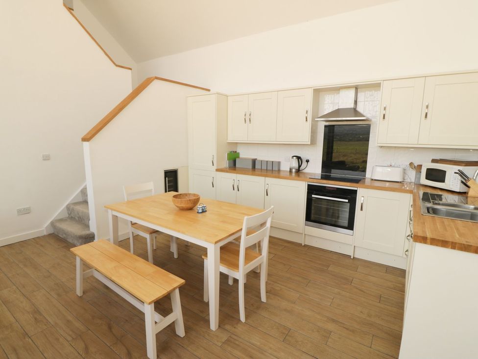 A kitchen with a table and chairs at Cae Mawr in Caernarfon