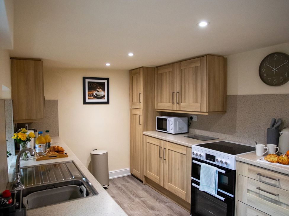 A kitchen with cabinets, sink, and microwave at Gap Farm in Brampton