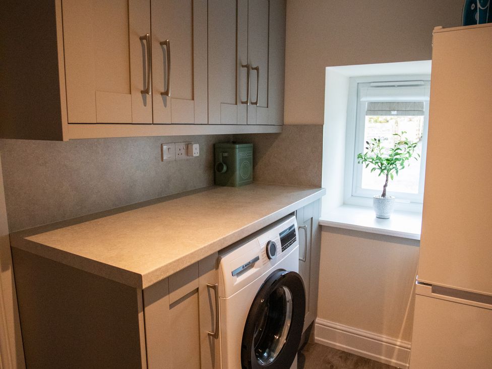A laundry room with a washing machine and refrigerator at Gap Farm in Brampton
