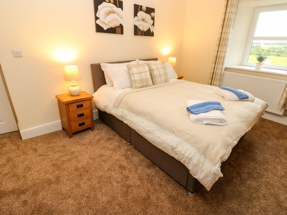 A bedroom with a bed and bedside table at Gap Farm in Gilsland