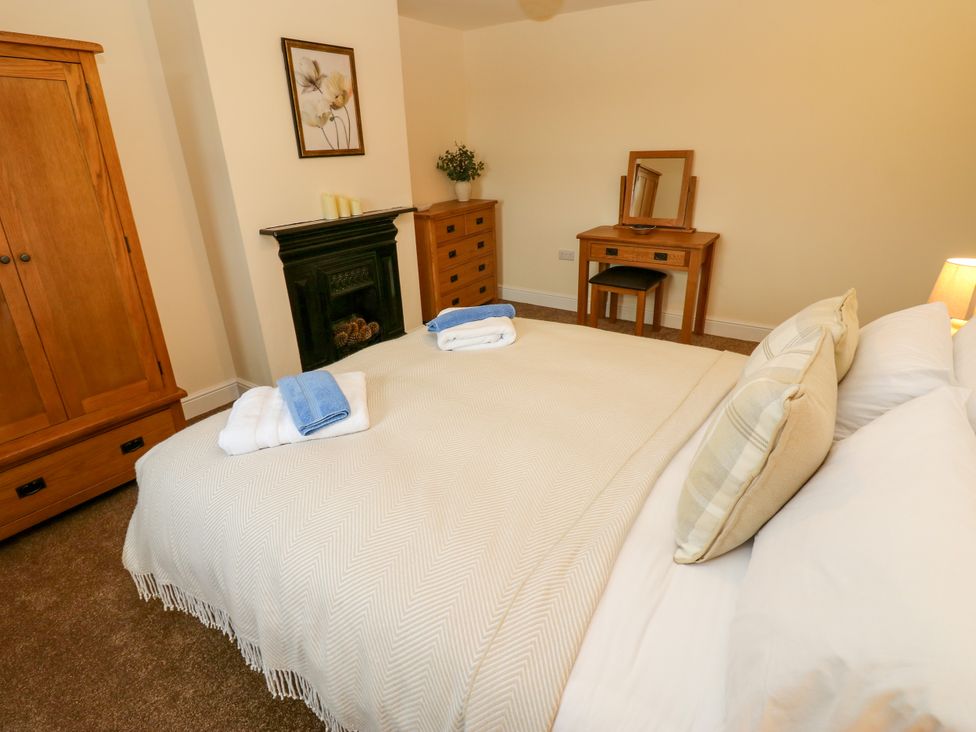 A bedroom with a bed and wardrobe at Gap Farm in Gilsland