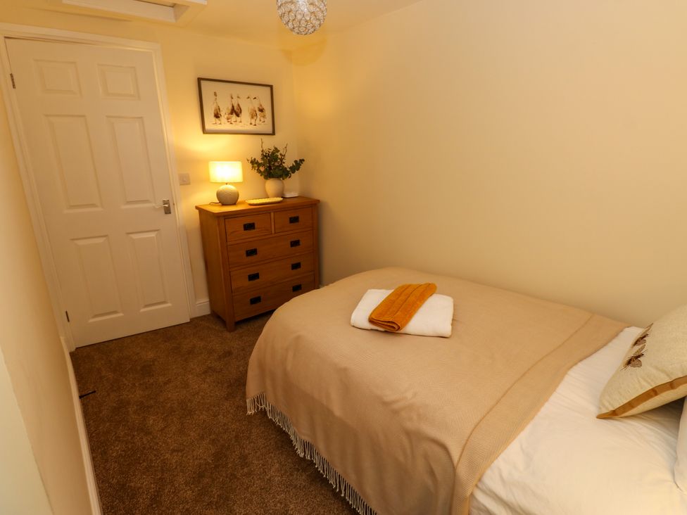 A bedroom with a bed and dresser at Gap Farm in Gilsland