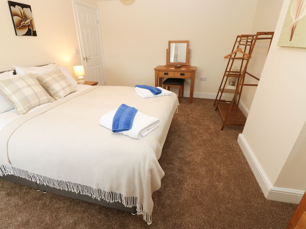 A bedroom with a bed and dresser at Gap Farm in Gilsland