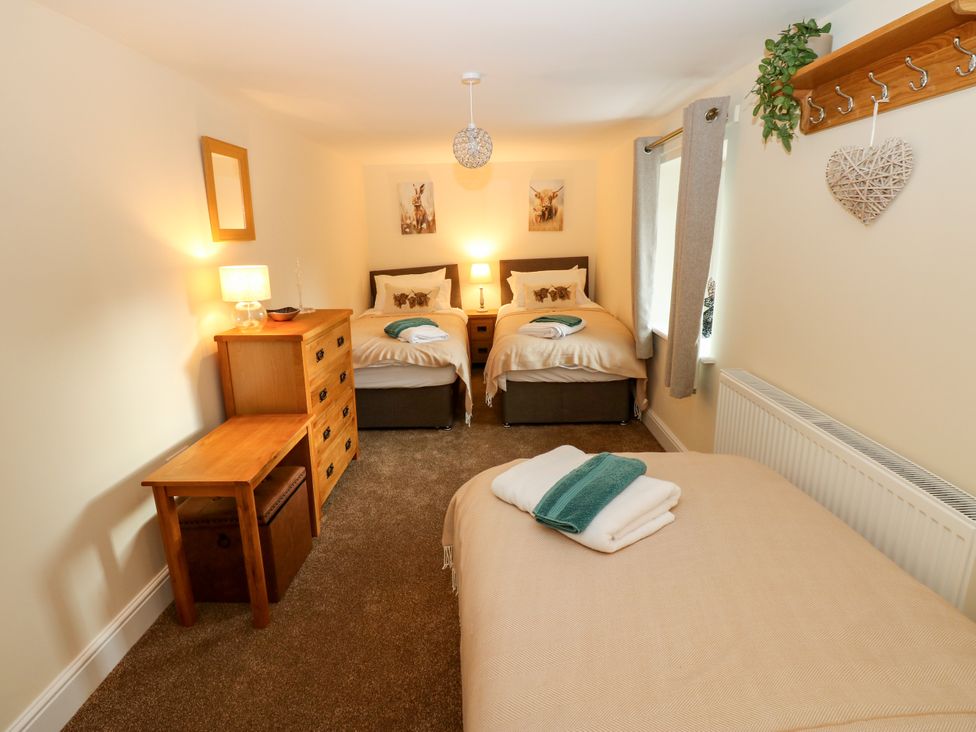 A bedroom with two beds and a dresser at Gap Farm in Gilsland
