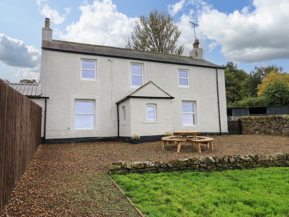 A house with table and chairs in the garden at Gap Farm in Gilsland