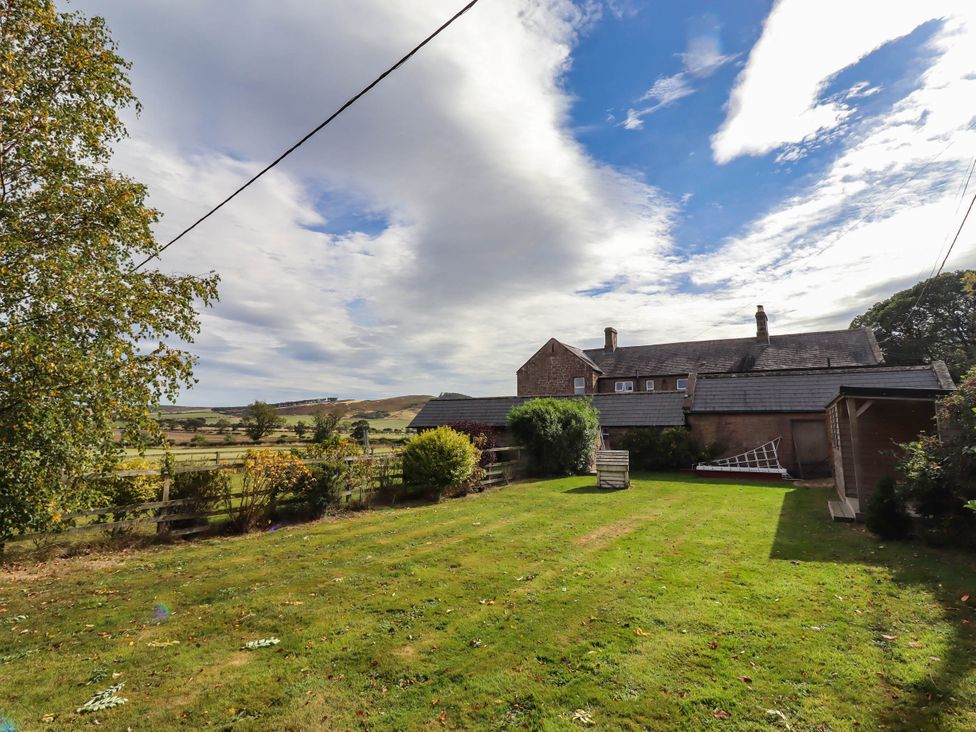 A garden with a house and trees at The Gables in Alnwick