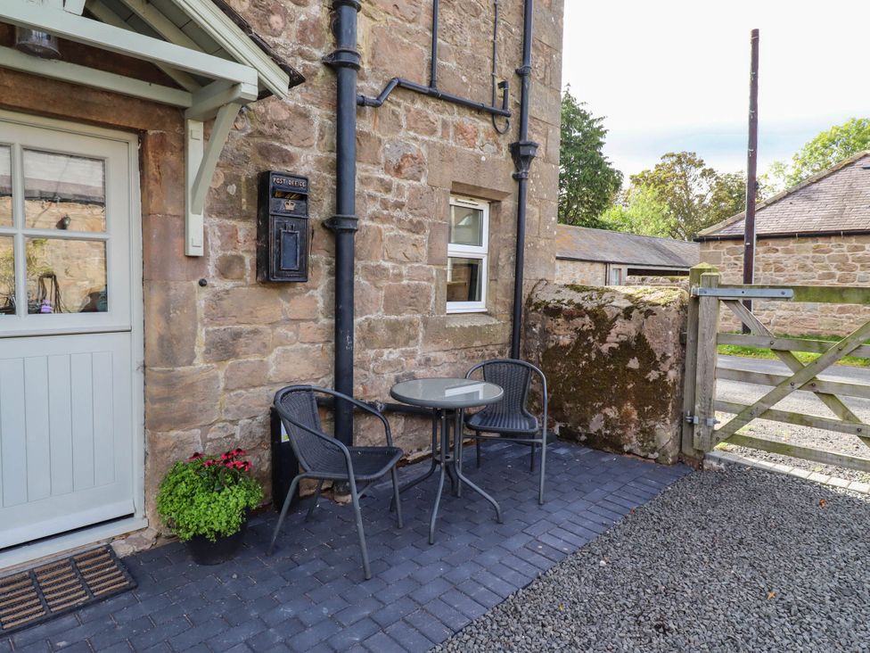 An outdoor seating area with a table and chairs at The Gables in Alnwick