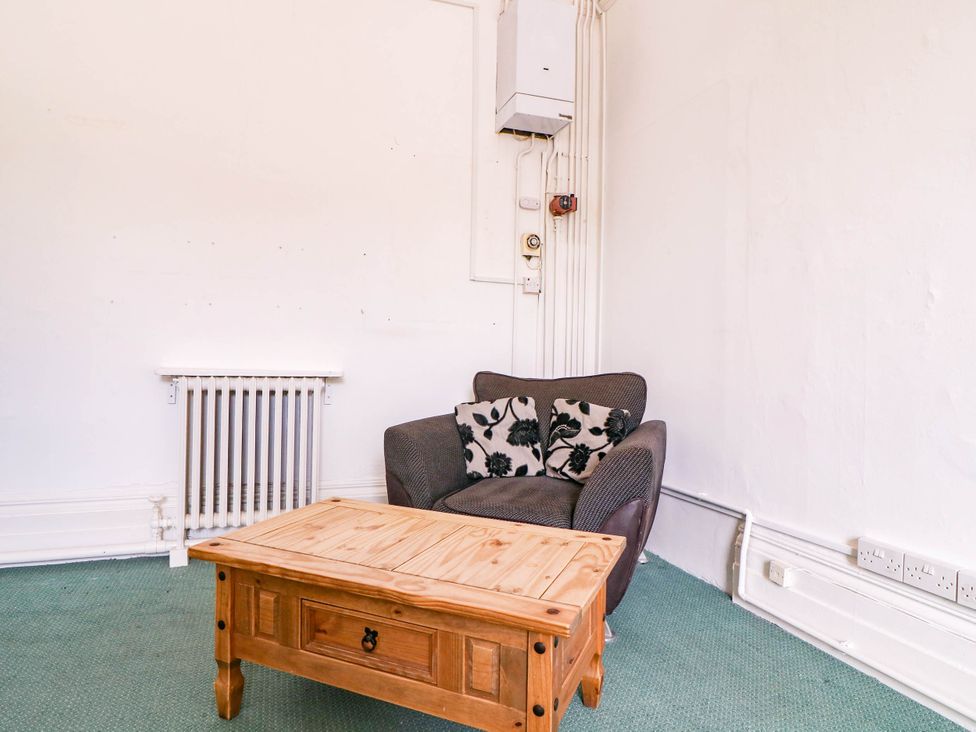 A living room with an armchair and coffee table at 6 Caxton Place Newport, South Wales