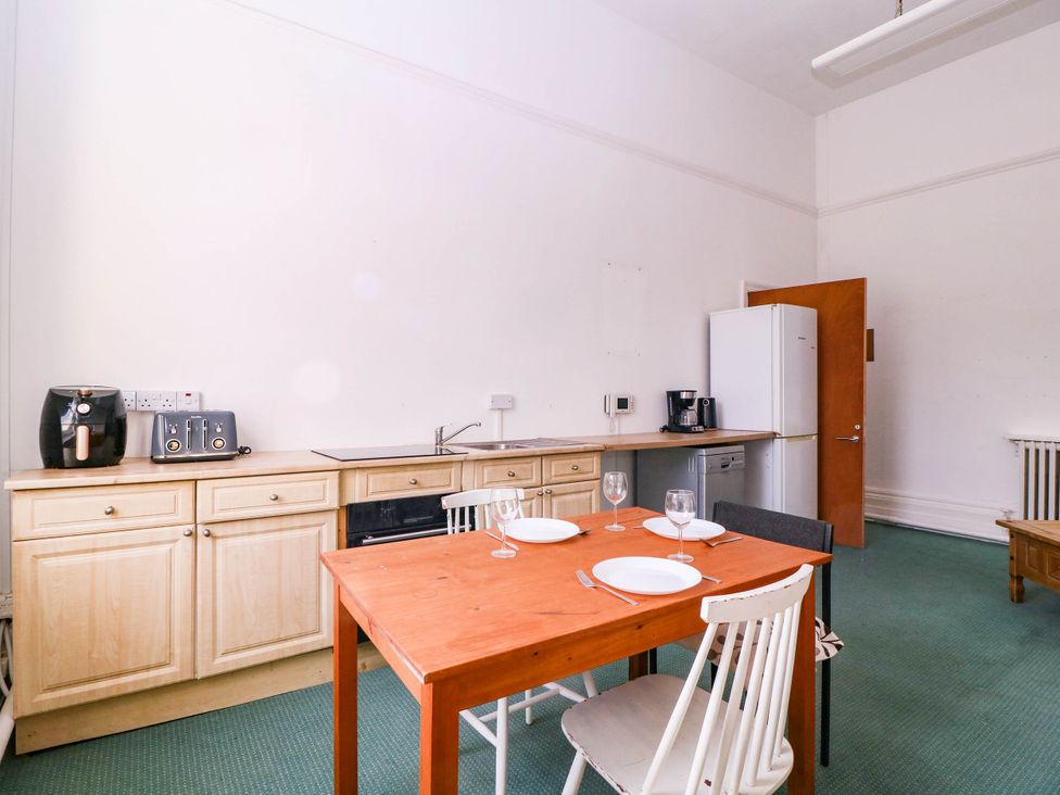 A kitchen with a dining table and appliances at 6 Caxton Place, Newport, South Wales