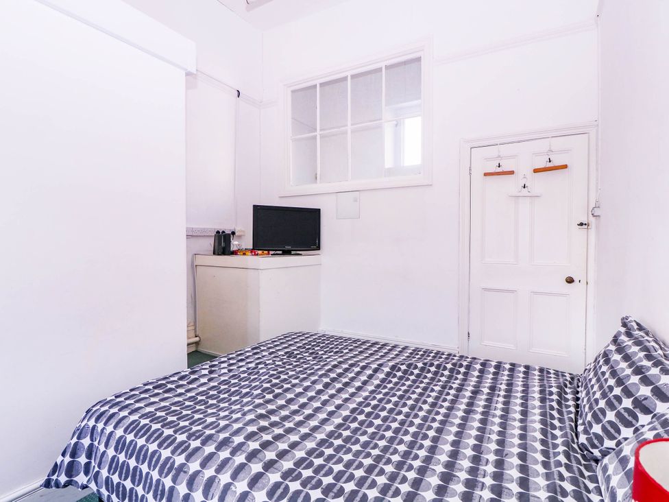A bedroom with a bed and television at 6 Caxton Place in Newport, South Wales