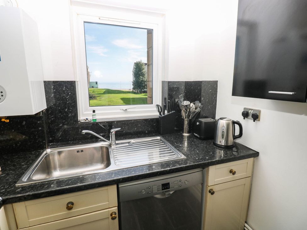 A kitchen with sink and appliances at 21 Ferrara Square Swansea