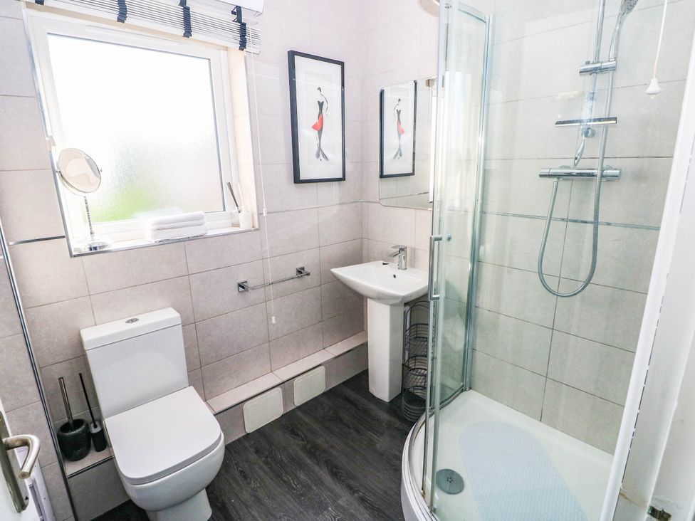A bathroom with a shower, sink, and toilet at 21 Ferrara Square Swansea