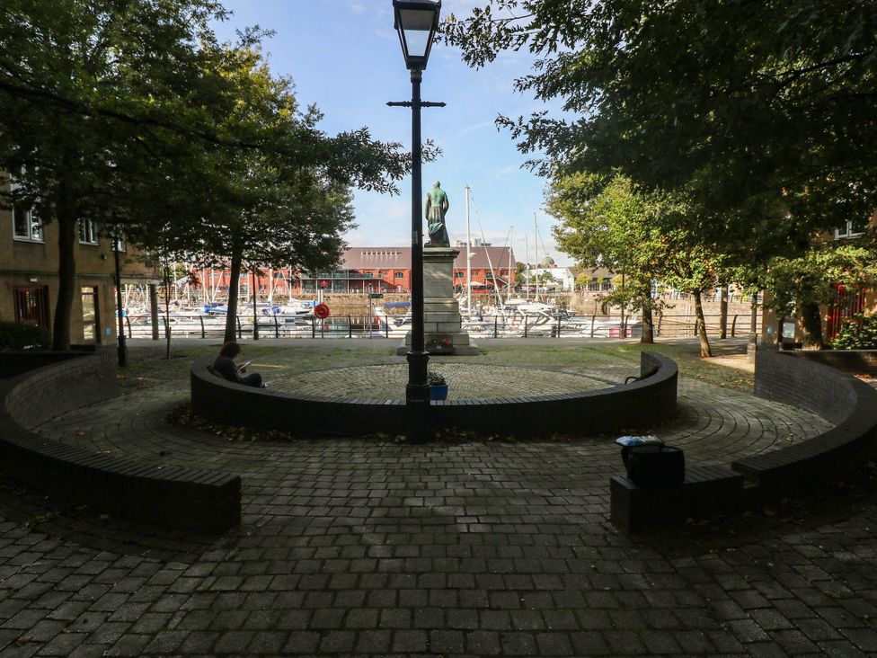 An outdoor area with a statue and circular seating at 21 Ferrara Square Swansea