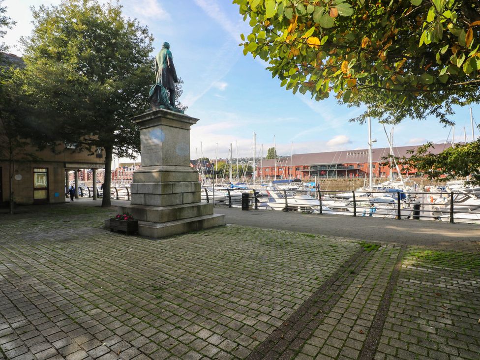 A statue near the water with boats at 21 Ferrara Square Swansea