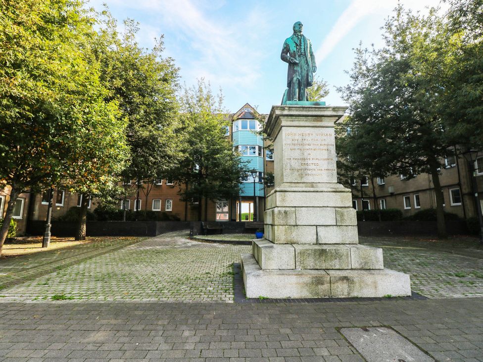 A statue on a plaza surrounded by trees at 21 Ferrara Square Swansea