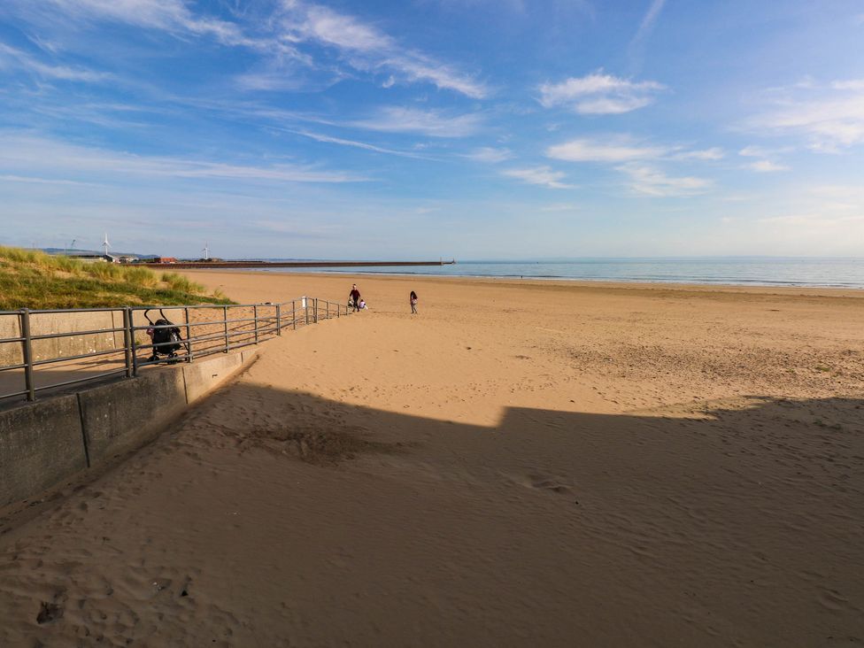 A beach with sand and people walking at 21 Ferrara Square Swansea
