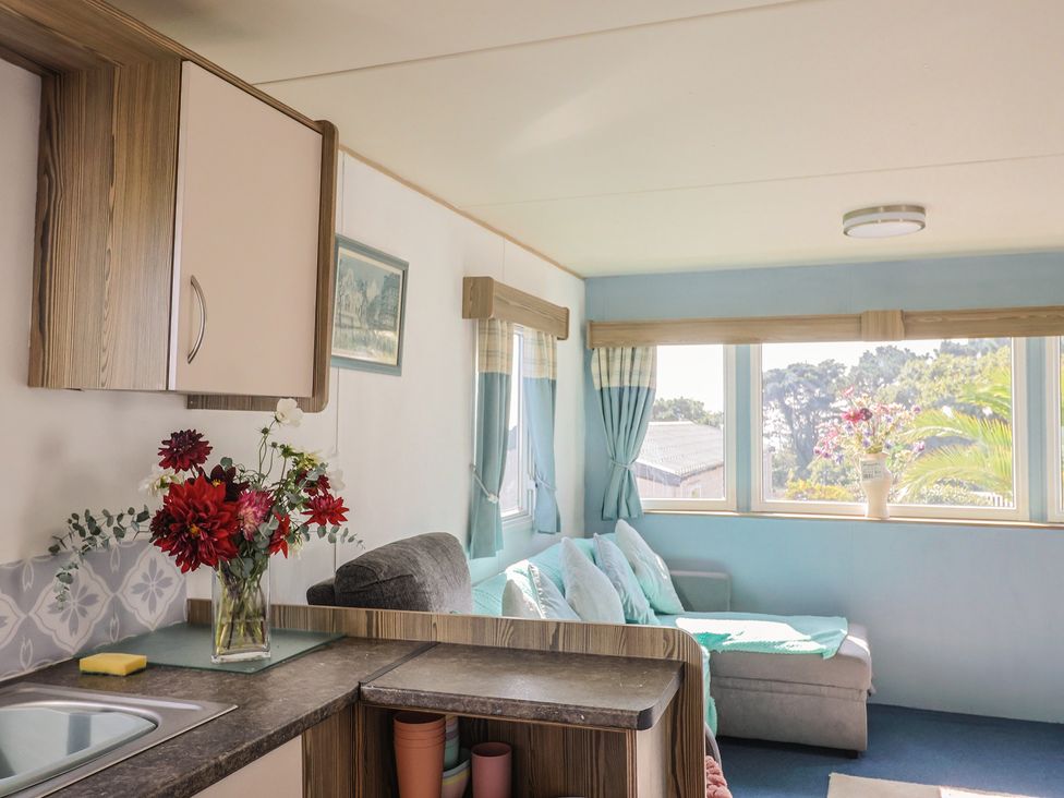 A living room with a couch and kitchen sink at Spruces 30 Sandy Bay, Exmouth