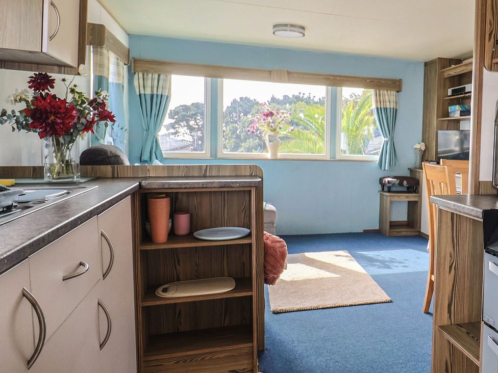 A living room with a kitchen counter and large window at Spruces 30, Sandy Bay, Exmouth
