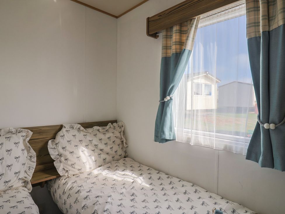 A bedroom with two beds and curtains at Spruces 30 Sandy Bay, Exmouth