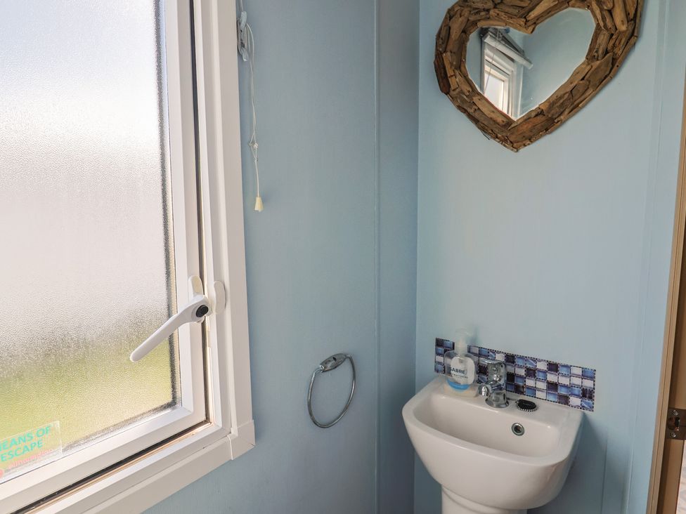 A bathroom with sink and mirror at Spruces 30 in Sandy Bay, Exmouth