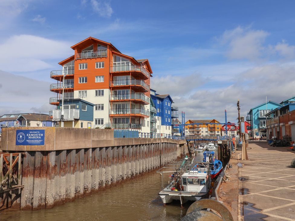A marina with boats and colorful buildings at Spruces 30, Sandy Bay, Exmouth