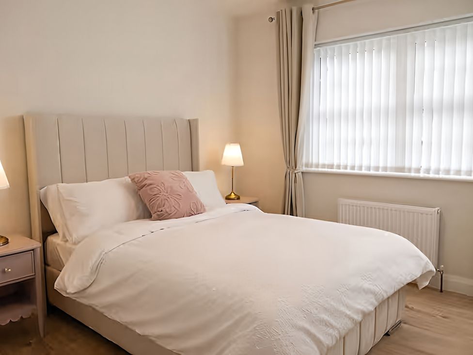 A bedroom with a bed and bedside lamps at Long Meadow Apartment in Portglenone