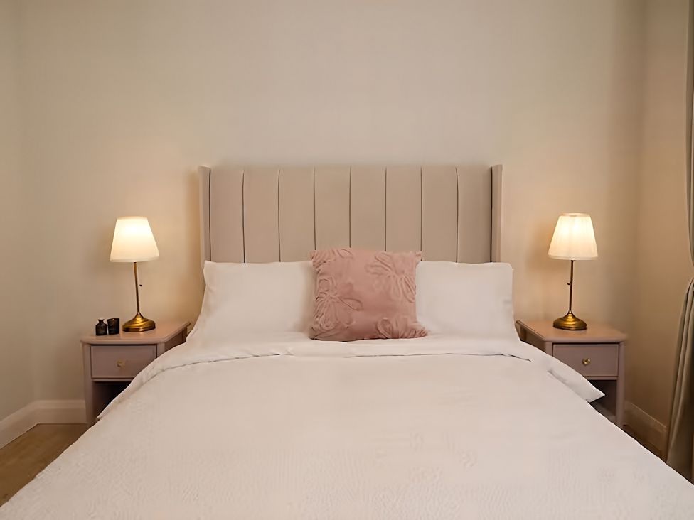 A bedroom with a bed and bedside lamps at Long Meadow Apartment in Portglenone