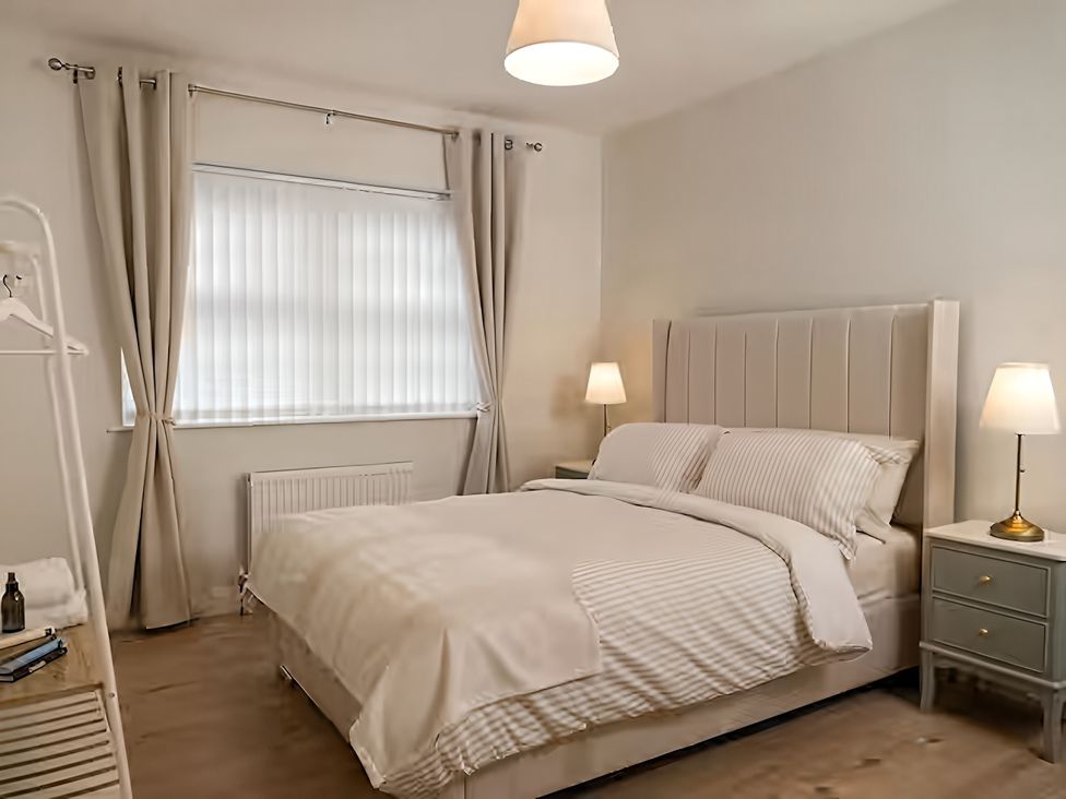 A bedroom with a bed and bedside tables at Long Meadow Apartment in Portglenone
